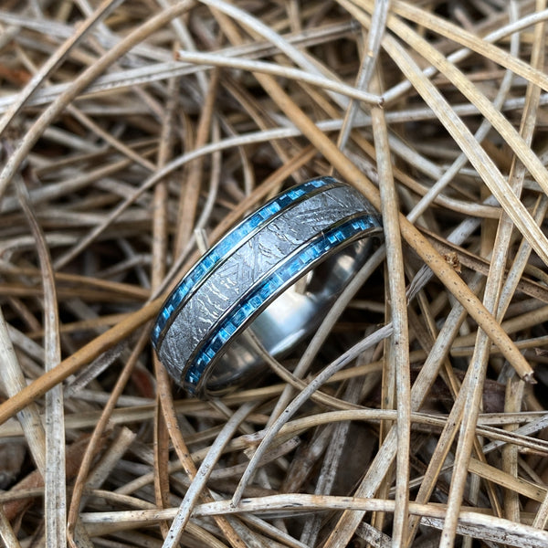 titanium ring with wide center meteorite inlay and twin light blue carbon fiber inlays on each side of meteorite